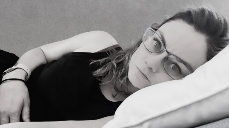 A photo I took in the aftermath of Will's SCA. You can see how I had dissociated – the light was gone from my eyes. It's black and white, and I'm laying on my side as I look directly at the camera.