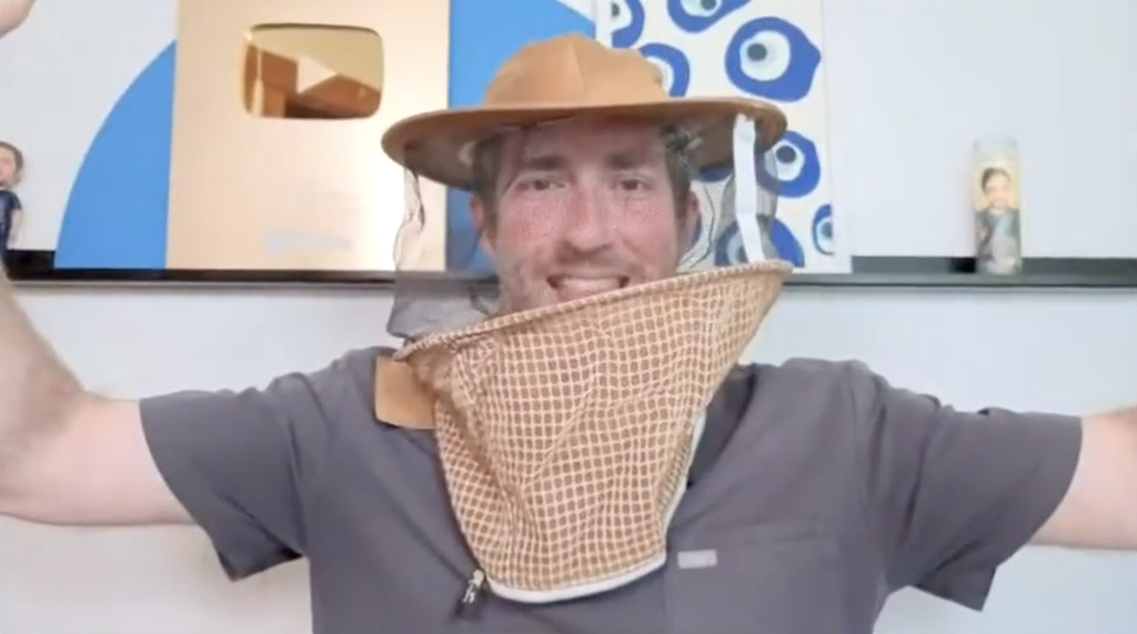 Dr. Glaucomflecken smiling and wearing a beekeeping hat.